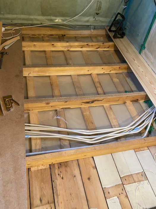 Renoverat golv med träreglar, rengjorda VP-rör och återmonterad sockel efter rensning från möss.