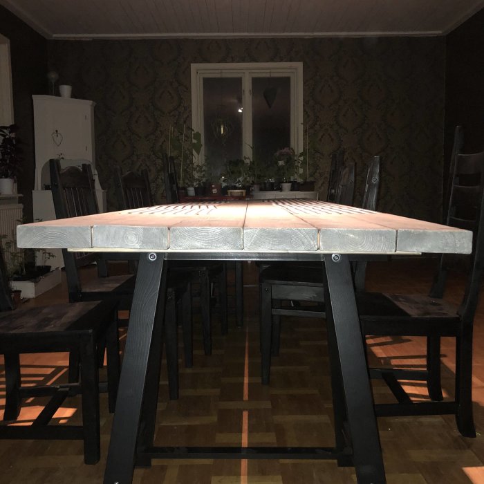 Ihopskruvade brädor på bordsskiva för en rustik look på svartbenta matbord i traditionellt rum.