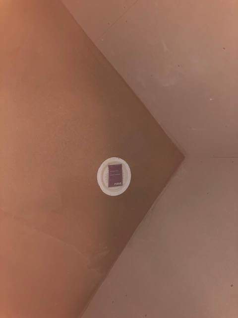 Golvbrunn i hörn av nykaklat badrumsgolv som en del av en renovering.