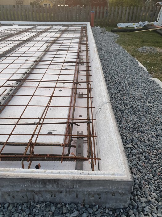 Förberedelse för gjutning visar golvränna på plats och armeringsmattor utlagda på en gjuten kantbalk.