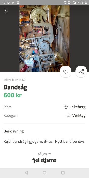 Använd begagnad bandsåg i gjutjärn på en rörig verkstad med verktyg och brädor i bakgrunden.