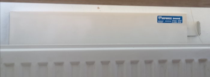 Vit radiator med ett ventilationsgaller ovanpå och Sefomix-etikett.