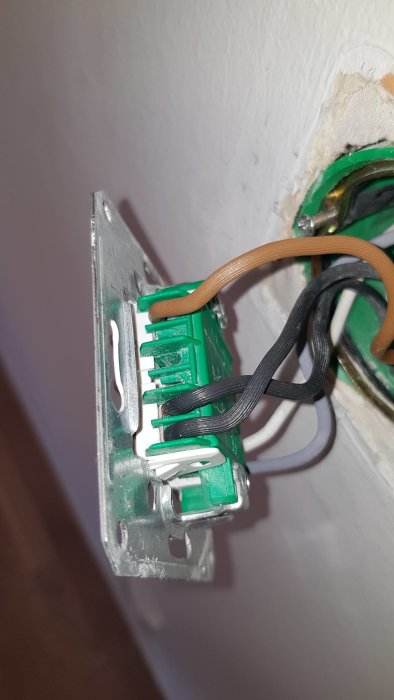 Öppen strömbrytare med svarta, bruna och gråa kablar kopplade, redo för installation av dimmer.