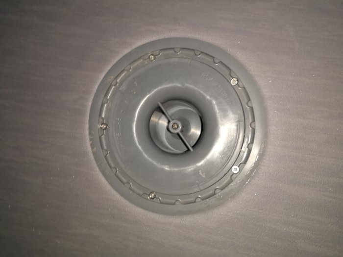 Inspektionsbild av en nyinstallerad avloppssil i en dusch under en badrumsrenovering.