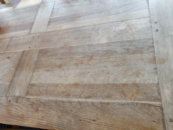 Obehandlat träköksbord med ojämn yta och brädor orienterade i olika riktningar.