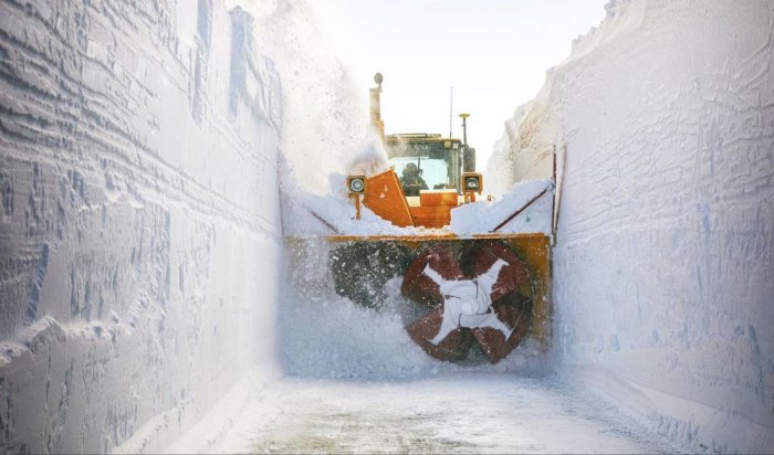 Snöröjningsfordon skjuter snö genom snövägg som är 3,5 meter hög på Vildmarksvägen.