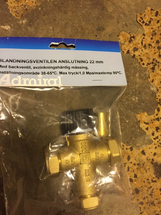 Ny blandningsventil i förpackning med texten "BLANDNINGSVENTILEN ANSLUTNING 22 mm" på ett marmorerat golv.