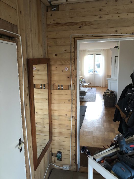 Renoveringsprojekt där gammal vägg rivits ut för att visa nydra elrör längs träreglar.