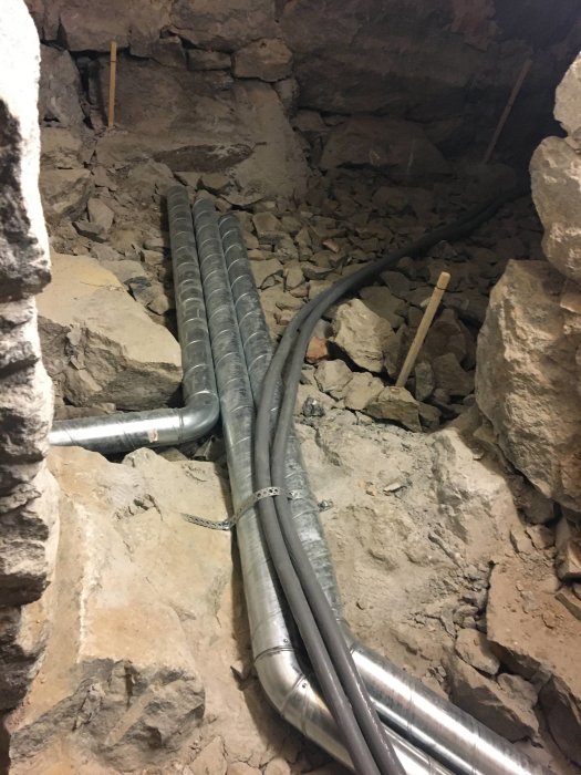 Installation av ventilation och värmegolv i en grusig och stenig källare.