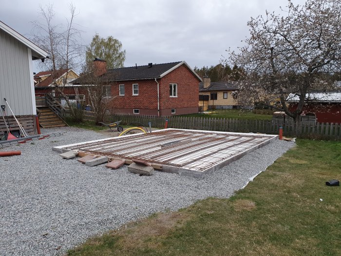 Förberedelse för gjutning med urkapade kantelement och förstärkt kantjärn i en trädgård.