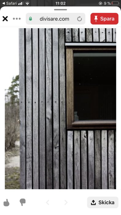 Vertikal träpanel med patina och ett fönster på väggförråd intill ett 60-tals hus.