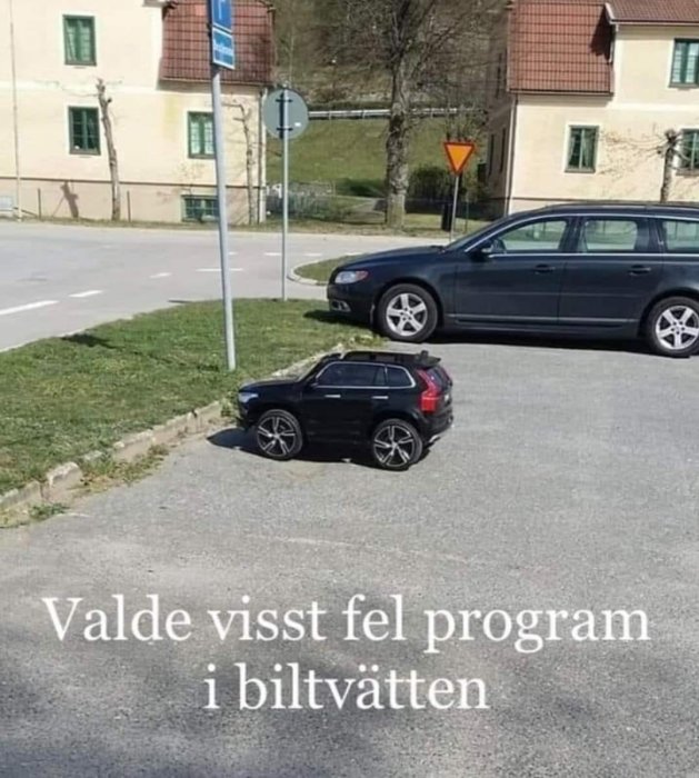 En liten leksaksbil bredvid en riktig bil på en parkeringsplats med texten "Valde visst fel program i biltvätten".
