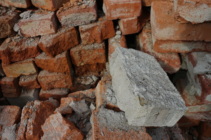Hög med gamla tegelstenar och murbruk för identifiering av asbesthaltigt material.