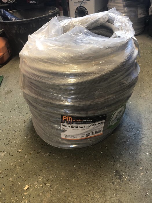 Rulle med PM Flex Next Zero elektrisk kabel, 5G1,5 100m, i plastförpackning på verkstadsgolv.