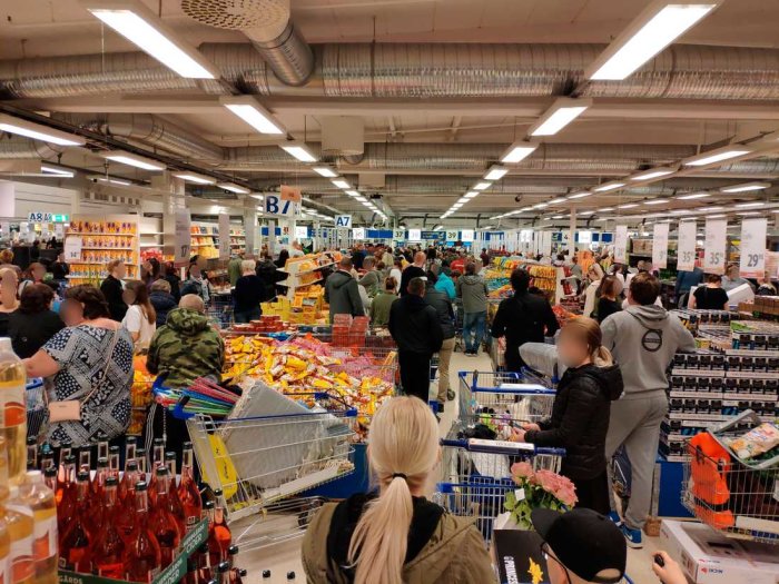 Trångt i en affär med många människor och fulla shoppingvagnar i gångarna.
