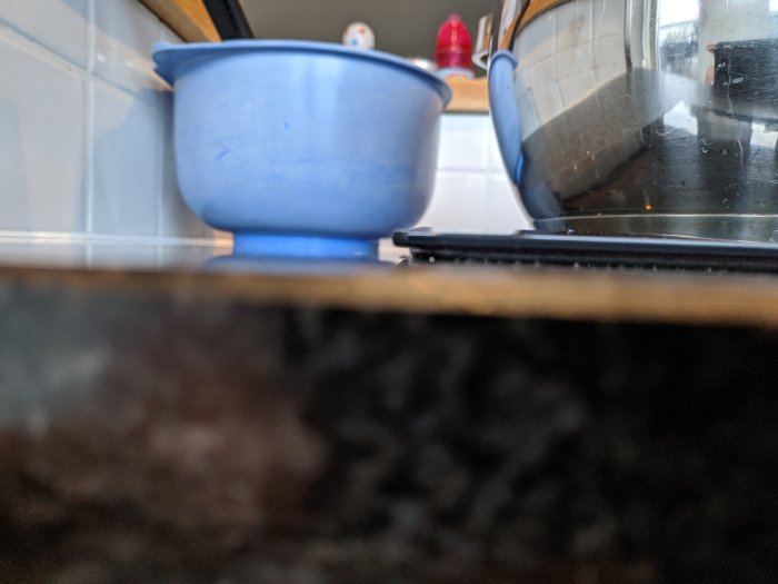 Nyinstallerad induktionshäll med synlig springa mellan häll och granitbänkskiva, närbild.