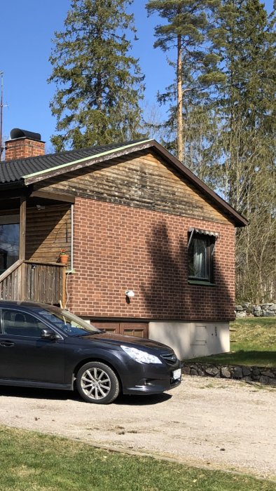 En tegelfasad på ett hus med möjliga mögel- eller smutsfläckar lämplig för tvätt före målning.