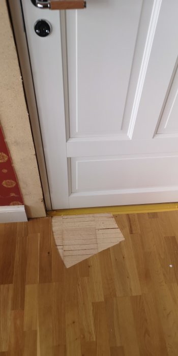 Parkettgolv med fräst utrymme vid dörr för att den ska kunna stängas.