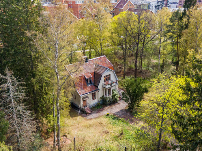 Flygbild av en villa omgiven av träd i ett bostadsområde, Tors Backe 4.