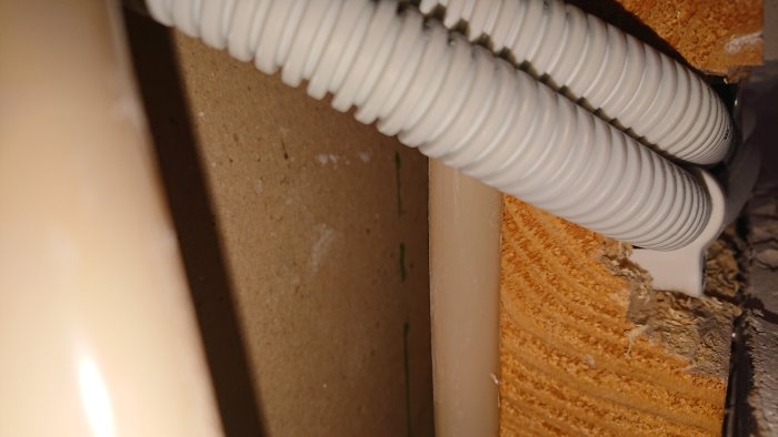 Elledningar dragna genom utsågade träbjälkar i vägg, risk för strukturell påverkan.