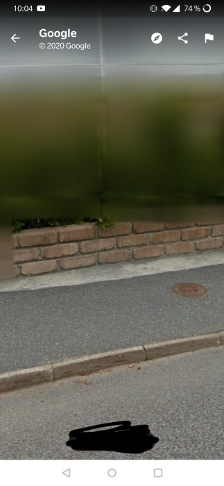 En låg mur vid trottoarkanten som ser oförändrad ut sedan bygglovet beviljades.