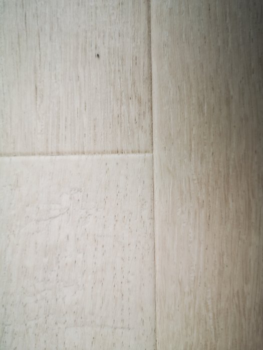 Pergo laminatgolvplankor med fasade kanter som är dåligt ihopfogade och visar kantförskjutning.
