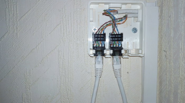 Nätverksinstallation i bostadsrätt med CAT 5 kabel i gammalt telefonrör och diskret dosa vid golvet.