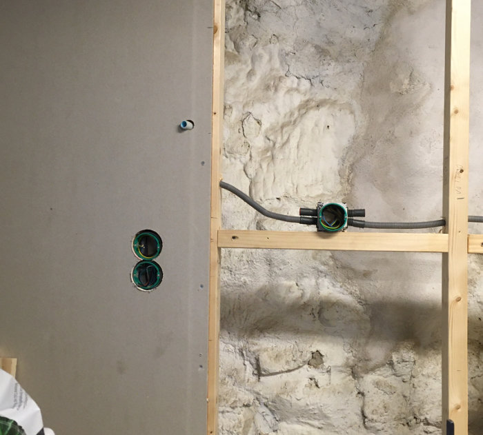 Eldrör omplacerat på en betongvägg för lampinstallation under köksskåp.