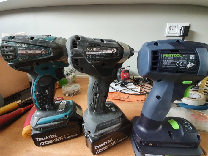 Tre olika slagborrar på ett bord, från vänster Makita LXDT01, Makita DTD155 och Festool TID18, alla med batterier monterade.