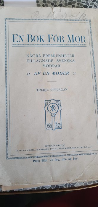 Omslaget till en gammal bok med titeln "En Bok För Mor" från 1911, tredje upplagan, publicerad av Svenska Kyrkans Diakonistyrelses Bokförlag.