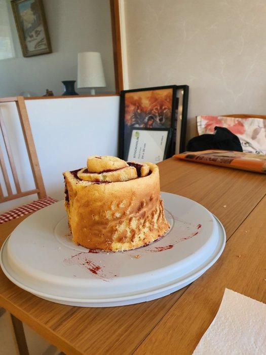 Hemgjord tårta med jordgubbssylt och gräddefyllning, toppad med färska bär och röd gelé, ser skadad ut.
