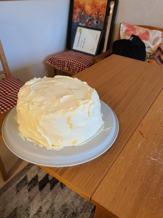 Hemmagjord tårta med grädde och vaniljsås yta, toppad med färska jordgubbar och hallon, lite skadad på sidan.