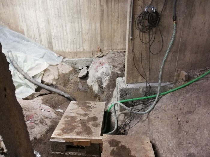 Nybyggd grusramp och gjutna stödmurar i en pågående byggarbetsplats inomhus.