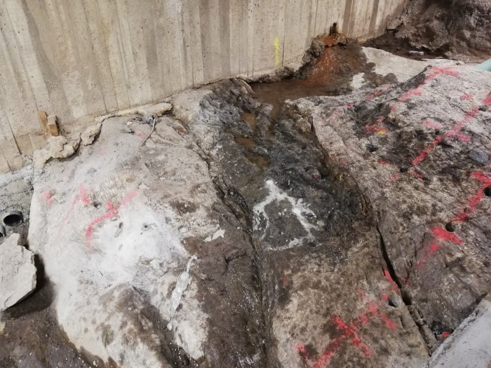 Nyggjuta stödmurar och markeringar för snigeldynamit på en byggplats.