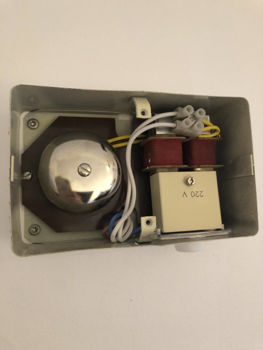 Elektrisk kassett med transformator och kopplingsklämmor på en vägg.