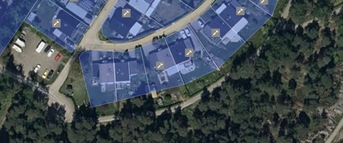 Satellitbild över ett bostadsområde med markerade fastighetsgränser och gemensamma grönområden.