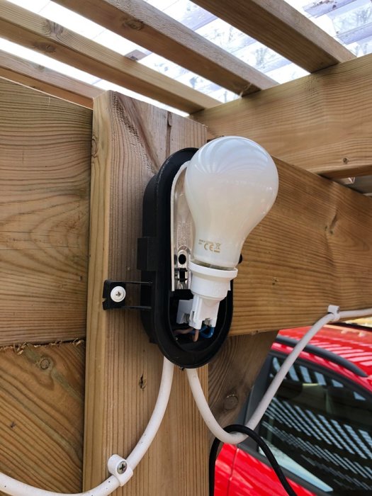 LED-lampa för stor för armaturen monterad på trävägg i carport.