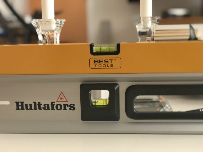 Närbild av Hultafors vattenpass med libeller i fokus, placerat på en yta.