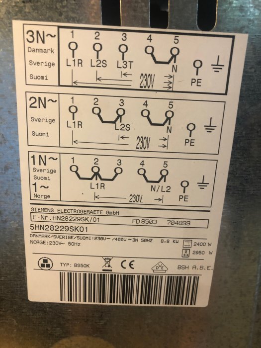 Bild på en klistermärke med schematisk elanslutning för en spis, med instruktioner för Danmark, Sverige och Finland.
