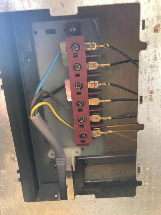 Elektriska anslutningar på en gammal spiskontakt med färgkodade sladdar.