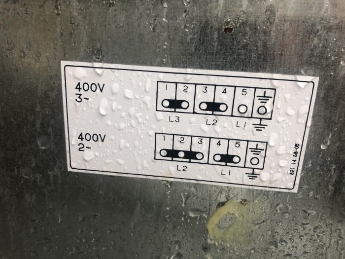 Instruktionsklistermärke för elektrisk anslutning med olika konfigurationer, blött av vattendroppar.