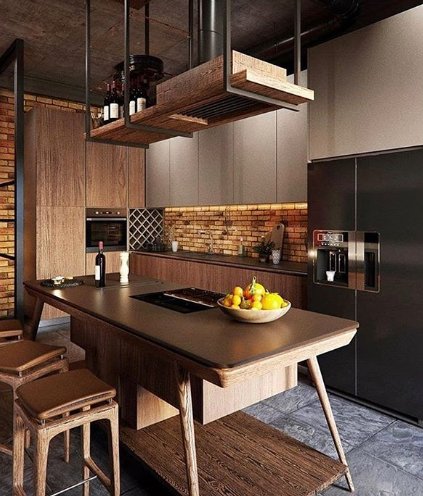 Modernt kök med råa material, takintegrerad köksfläkt bakom galler, central spishäll och open shelving.