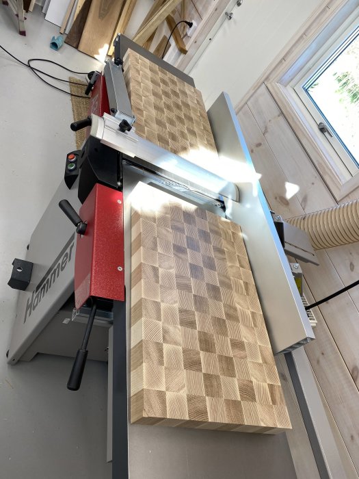 Två handgjorda ändträskärbrädor i ek och ask på en hyvelbänk.