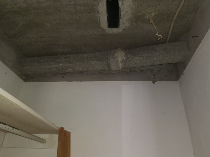 Betongtak med spår efter avlägsnade eternitkanaler och synliga ledningar.
