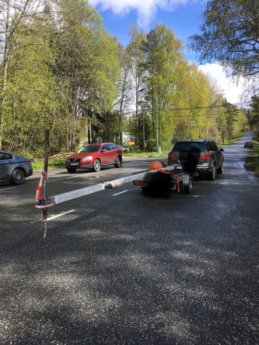 Släpvagn med negativt kultryck parkerad på en gata med bilar i bakgrunden.