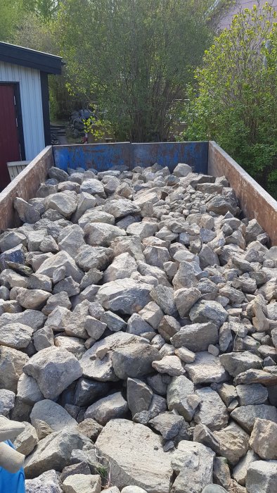 Lastbilflak fyllt med stora stenblock redo för transport.