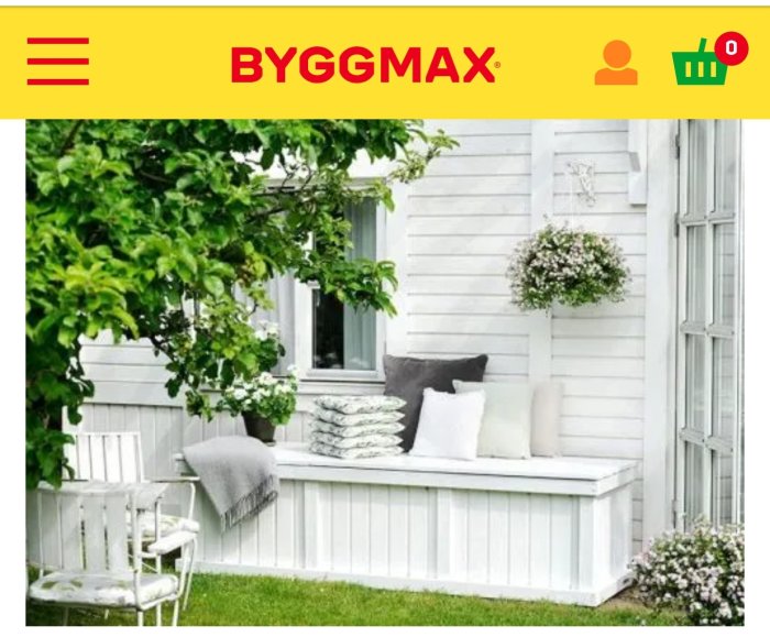 Vit träveranda med inbyggd sittbänk och kuddar utanför ett hus, samt en blomkruka på stolpen.