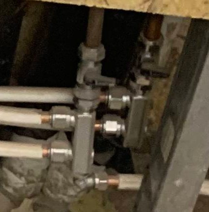 Suddig bild på VVS-installerade dubbelmuttrar och minikulventiler, eventuellt märkena Vatette och Broen Ballofix.