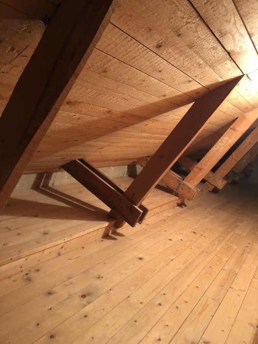 Trätakstolar och golv på en vind från ett hus byggt 1959, som kan vara en del av en byggdiskussion.