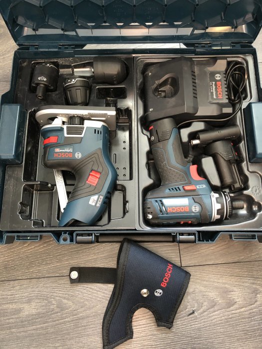 Öppen verktygslåda innehållande en handöverfräs och en borrskruvdragare från Bosch, ordnade nätt bredvid varandra.